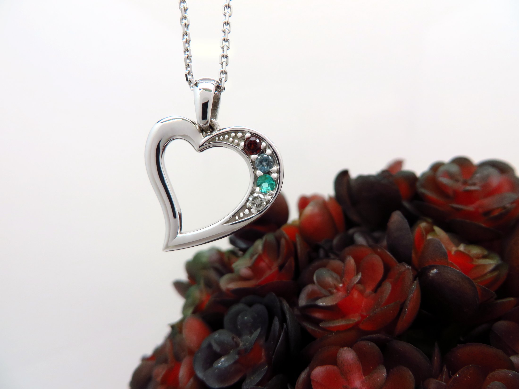 Pendentif Familial, Or Blanc Serti D'un Grenat, Une Aigue-marine, Une émeraude Et Un Diamant.