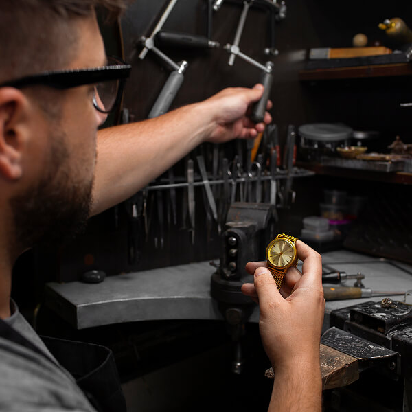 Horloger local ajustant une montre dans son atelier, illustrant pourquoi l’expertise locale fait toute la différence.