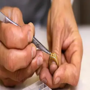 Une personne utilise des ciseaux pour couper un anneau en métal.